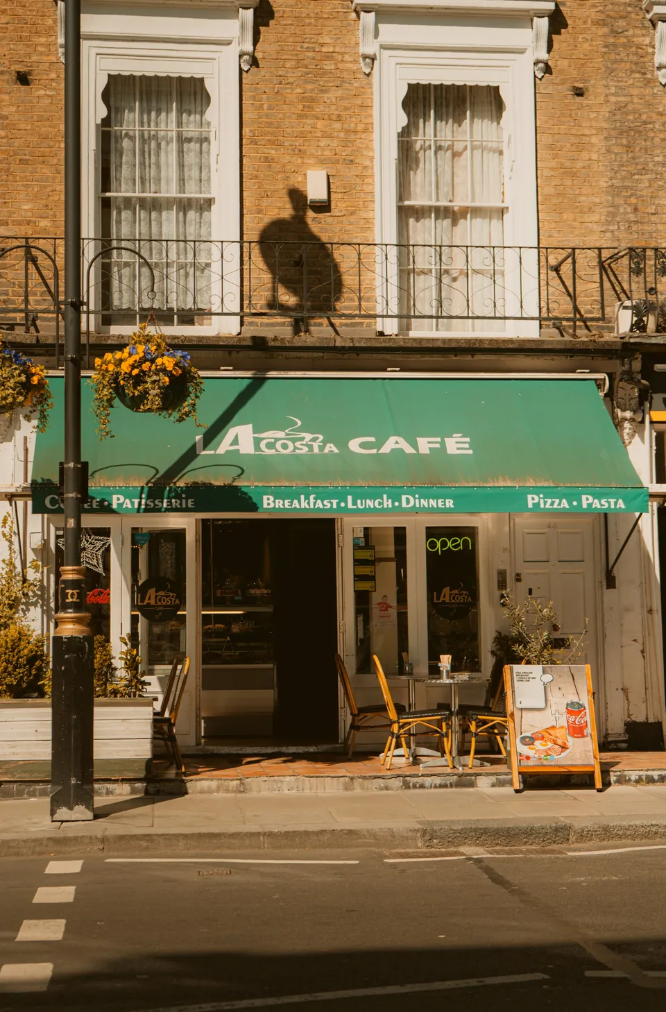 La Costa café in London, with a green awning and outdoor tables in daylight